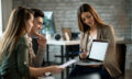 Happy couple and their insurance agent using laptop on a meeting in the office.